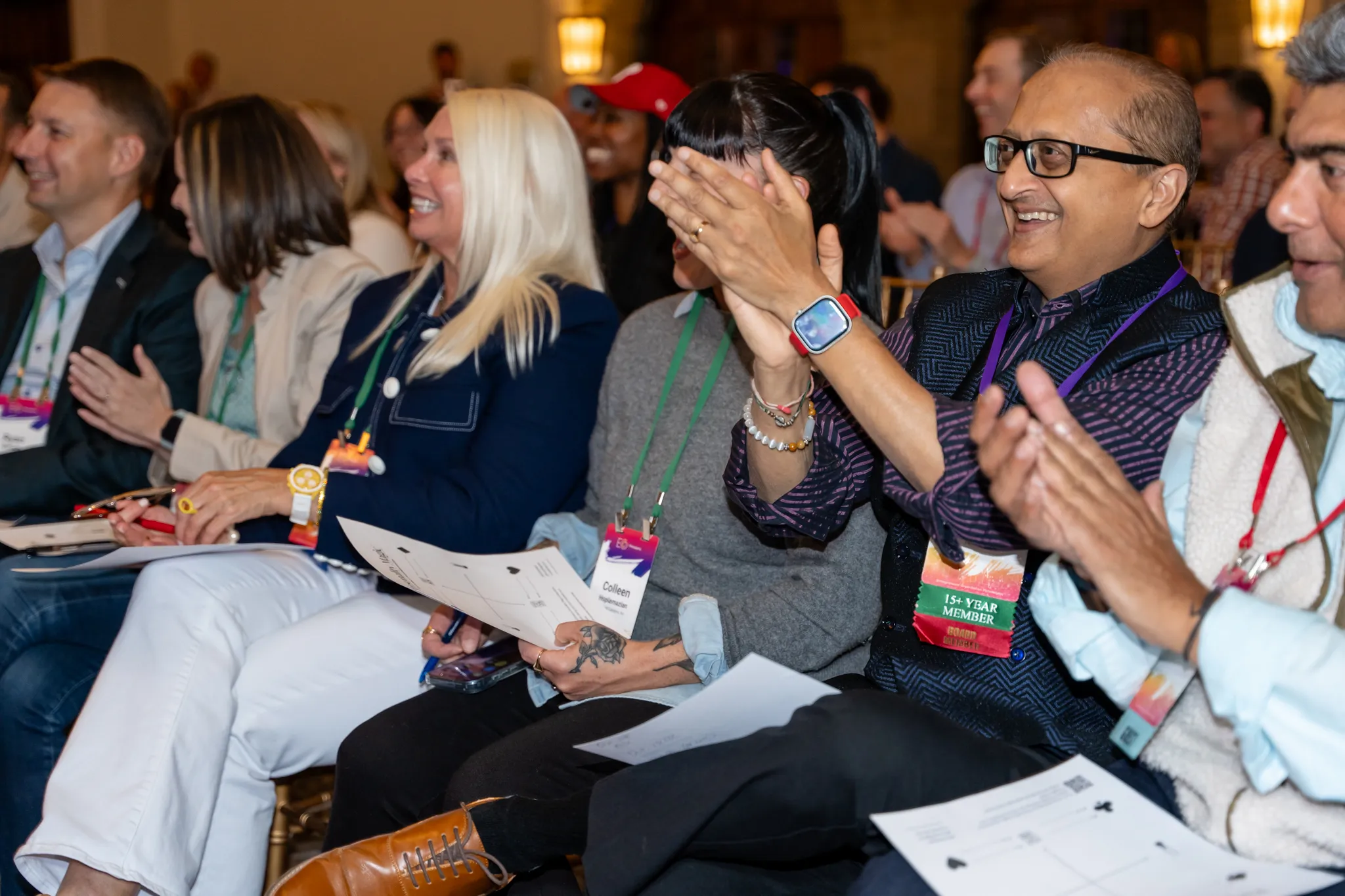 Attendees laughing and applauding with their Personality Magic worksheets in their laps