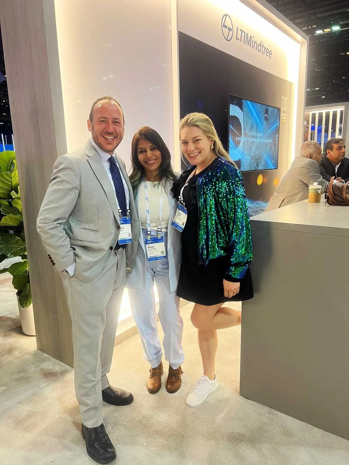 Kostya Kimlat with two members of the LTIMindtree team in front of their branded stand at SAP Sapphire
