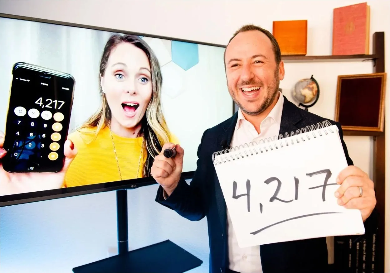 A guest holds up a phone reading 4,217 while Kostya Kimlat holds a pad with the same number